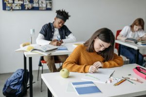 élèves étudiant en classe en train d'écrire un devoir