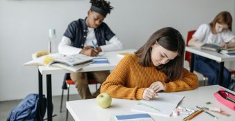 élèves étudiant en classe en train d'écrire un devoir